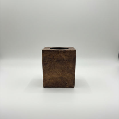 A rustic dark brown wooden box with a circular cutout on top.