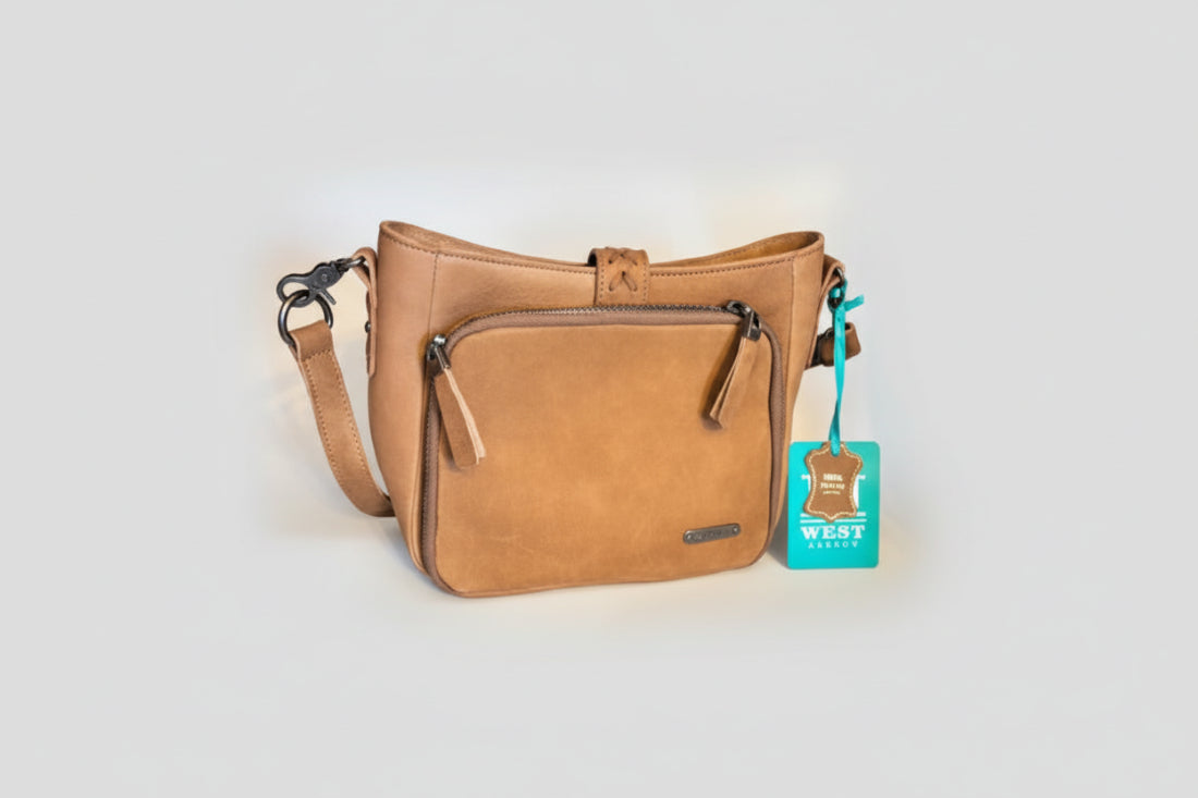 Brown leather handbag with a visible brand tag on a white background