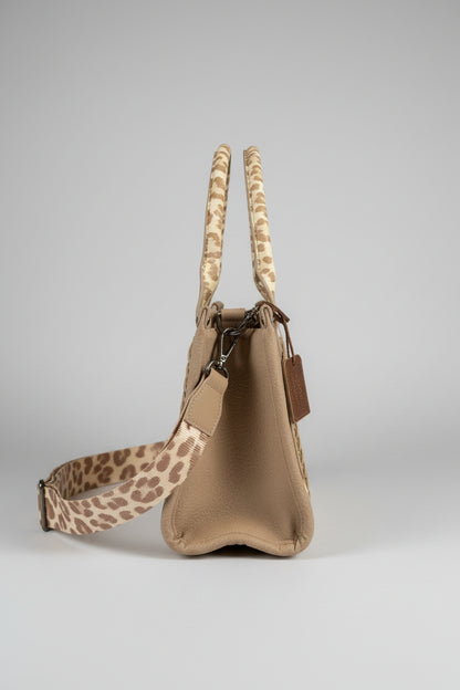 Beige handbag with patterned strap on a white background