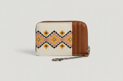 Small pouch with brown leather top and patterned fabric body on a beige background