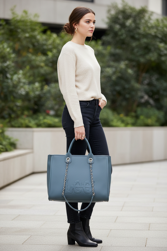 Woman holding a blue handbag in an outdoor setting