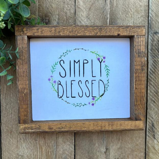 wood farmhouse framed sign that reads simply blessed on spring flower backgroud