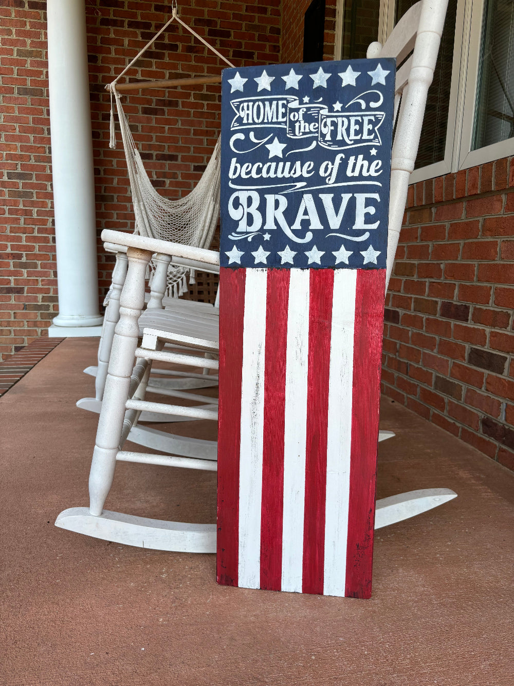 Decorative sign with American flag design on a porch