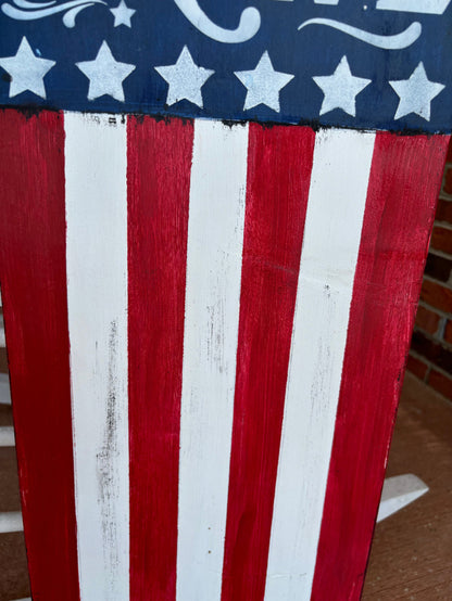 Close-up of a wooden American flag with visible grain and texture.