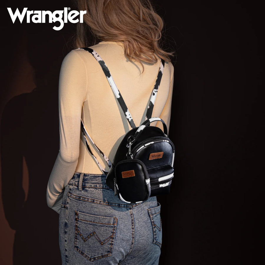 Person wearing a black mini backpack with 'Wrangler' branding on a dark background