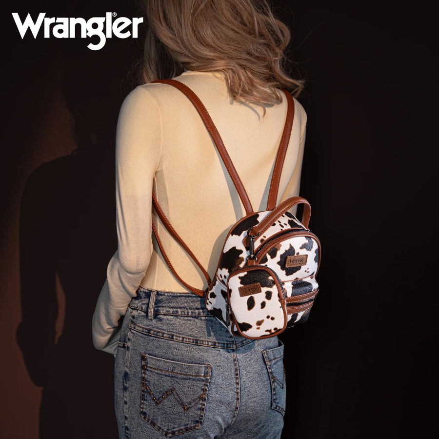Person wearing a cow print mini backpack with Wrangler branding