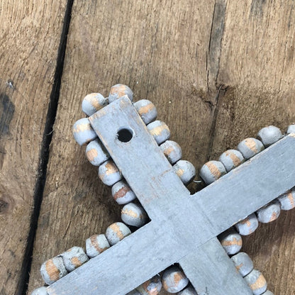 back of grey wood cross showing hole for hanging on wall