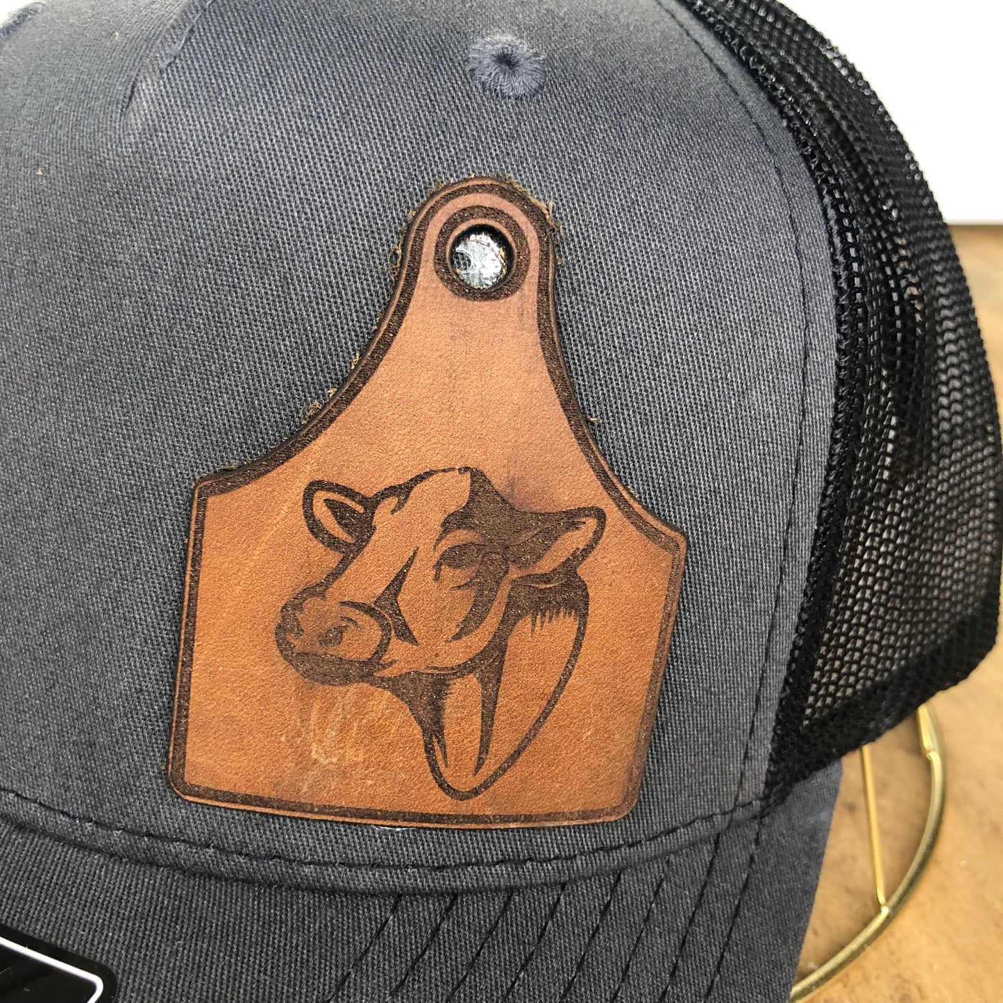 close up of leather heffer cow patch on grey richardson hat