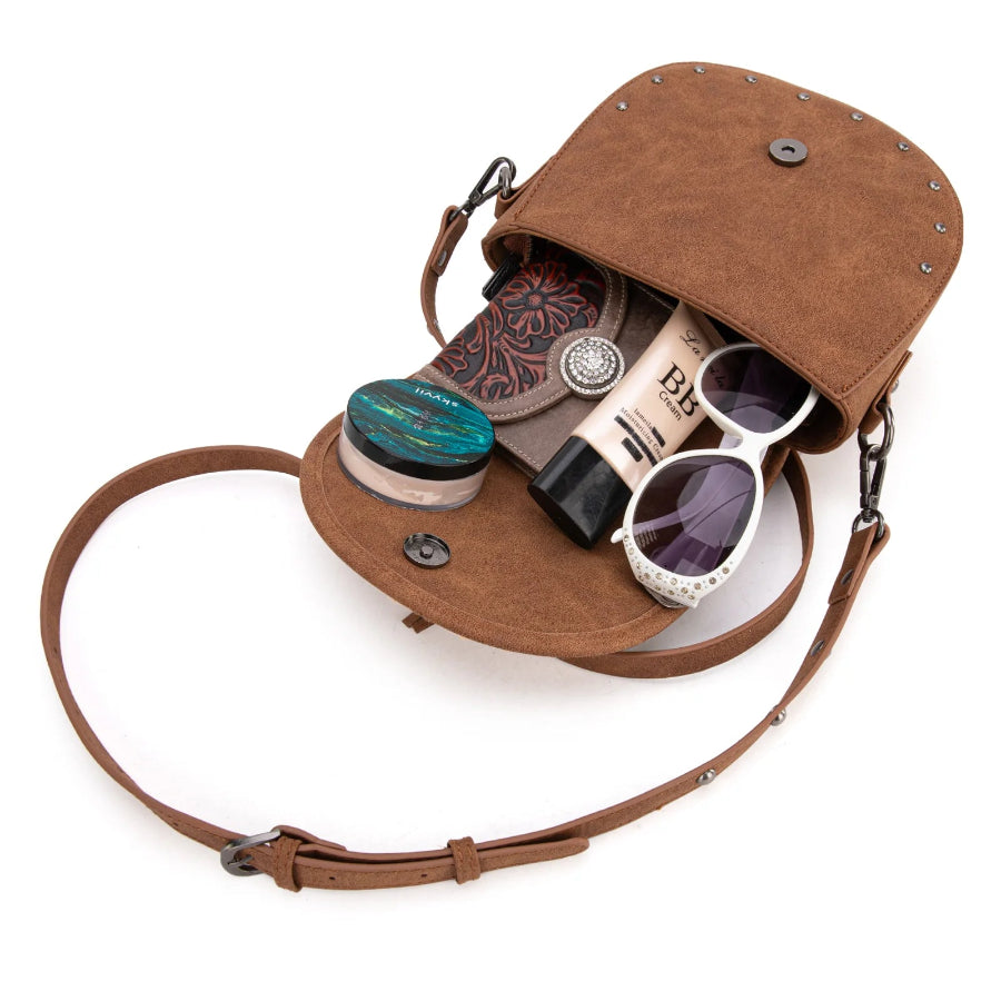 Brown leather crossbody bag with sunglasses and other items on a white background