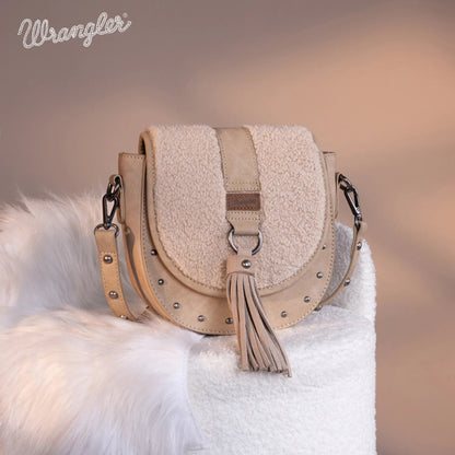 Beige handbag with tassel on a fluffy white surface, Wrangler brand visible