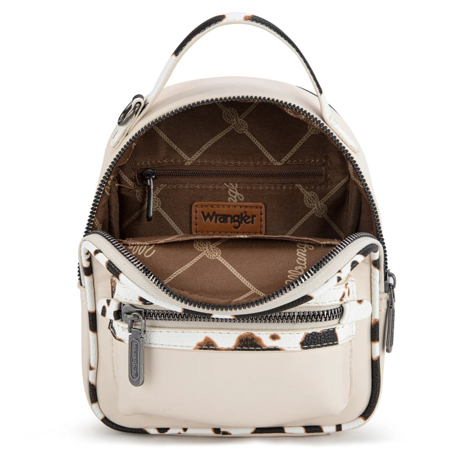 Small tan backpack trimmed with cow print pattern on a white background