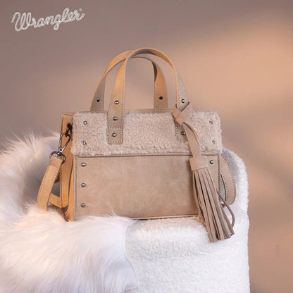 Beige handbag with fringes on a white fur surface, Wrangler brand visible