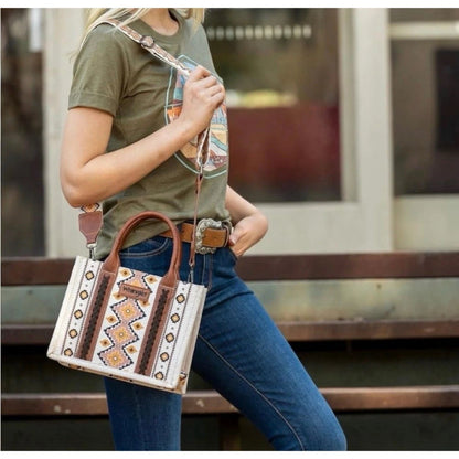 Person holding a patterned handbag with a blurred background