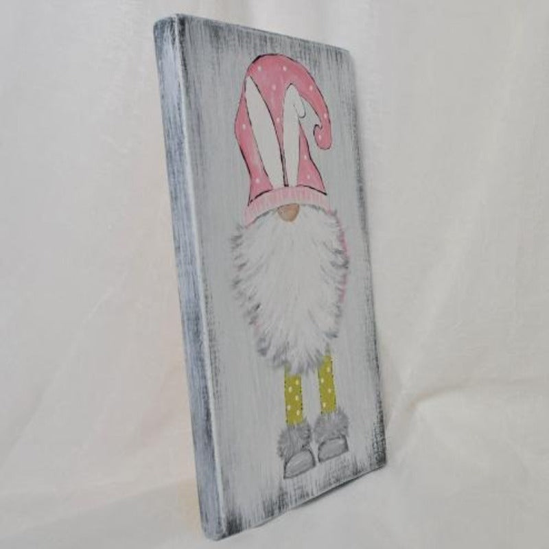 bunny gnome with pink hat and white bunny ears on distressed wood sign side view