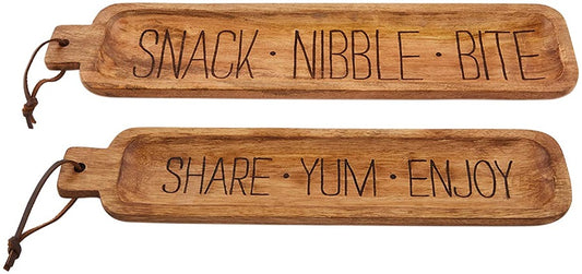 set of 2 nested mango wood snack trays. large one reads snack, nibble, bite. smaller one reads share, yum, enjoy.