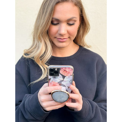 young woman with her cell phone and stylish geode phone grip.