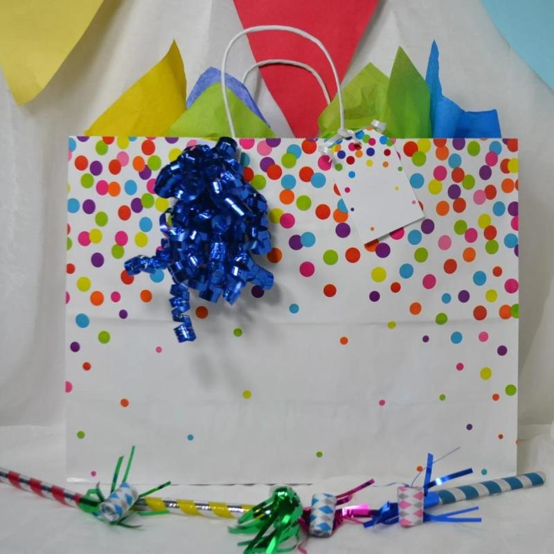 Rainbow Confetti Gift Bag with blue curly ribbon bow and coordinating name tag and tissue paper